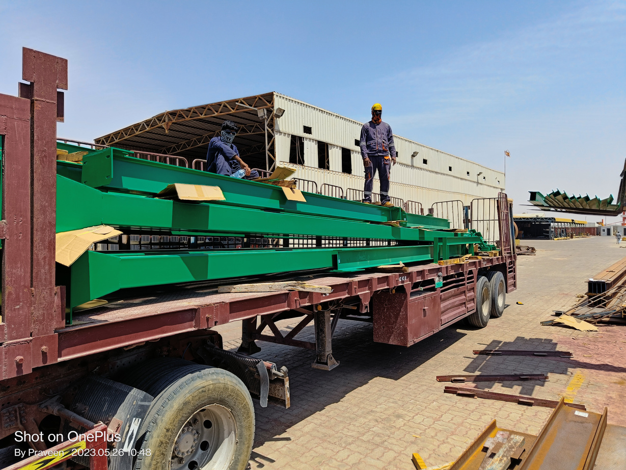 Men loading Fabricated and Painted steel H-Beams on a trailer