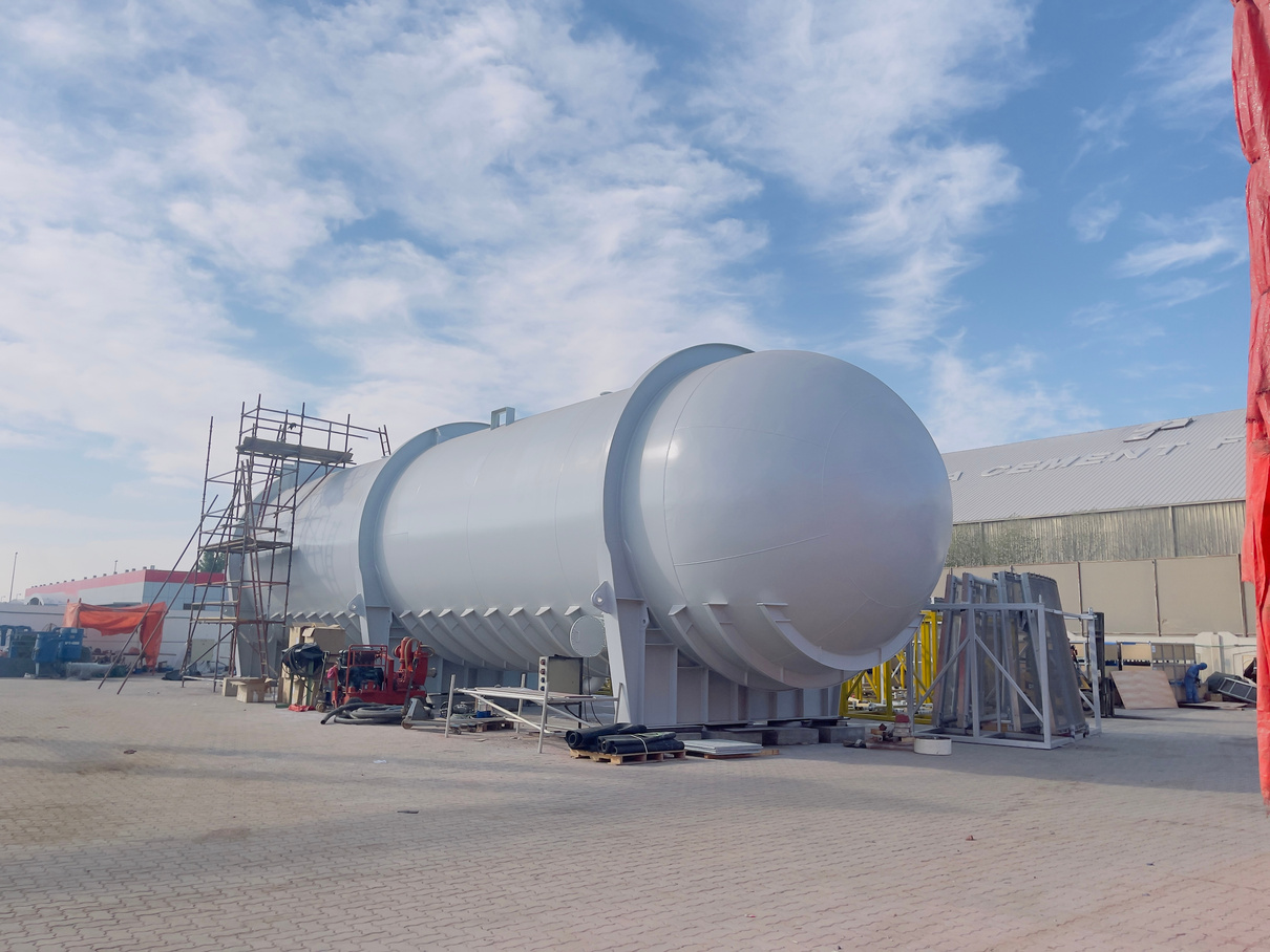 A large pressure vessel that is painted with scaffolding put around it